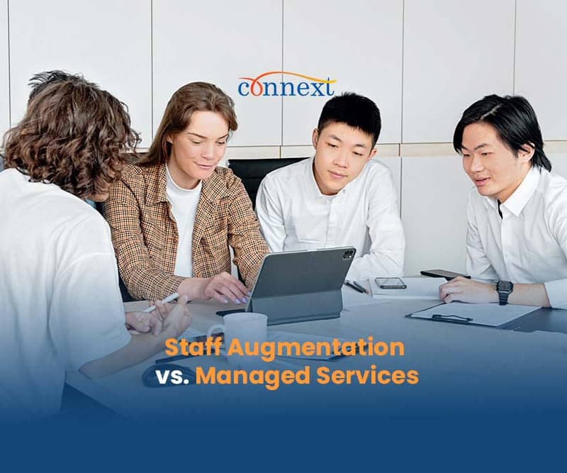 Staff-Augmentation-vs.-Managed-Services-5-people-asian-causasian-in-a-meeting-using-laptop-inside-office