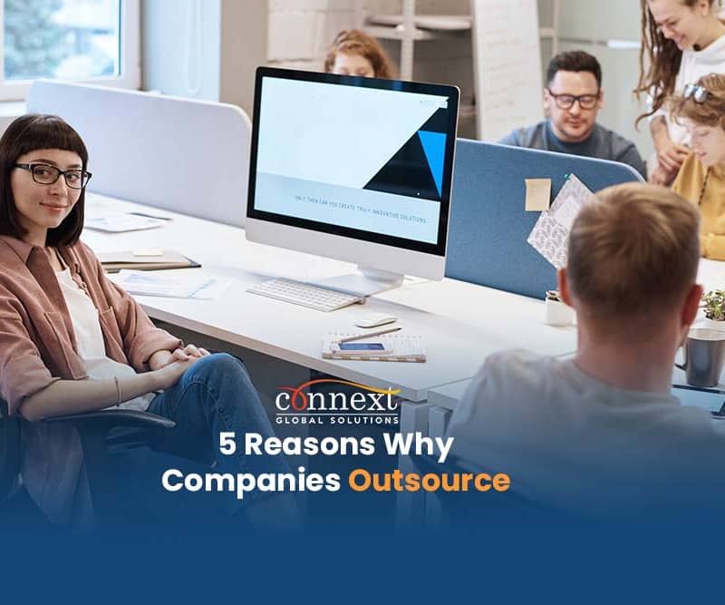 5-Reasons-Why-Companies-Outsource-woman-in-office-desk-space-with-co-workers