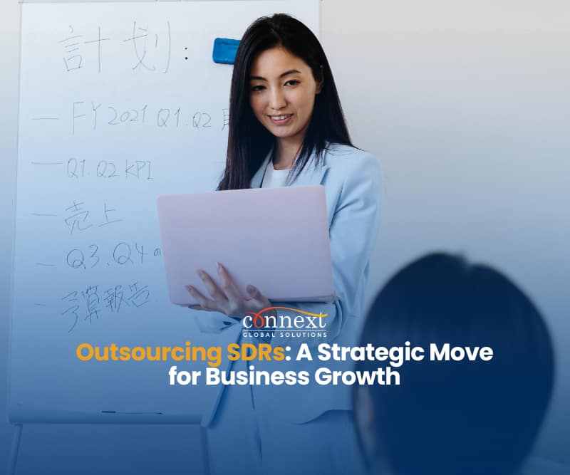 Outsourcing-Sales-Development-Representatives-SDRs-A-Strategic-Move-for-Business-Growth-asian-woman-in-corporate-attire-holding-laptop-with-whiteboard