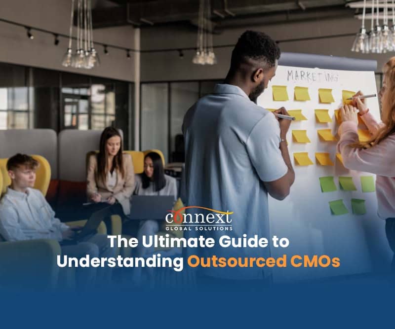 The Ultimate Guide to Understanding Outsourced CMOs People in corporate attire brainstorming using whiteboard in office