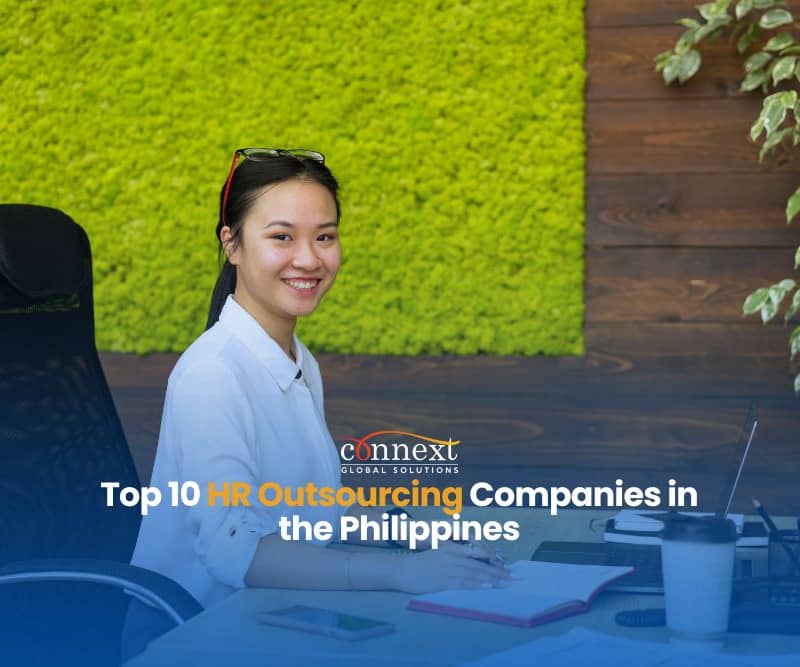 Top-10-HR-Outsourcing-Companies-in-the-Philippines-asian-woman-corporate-attire-smiling-sitting-in-office-chair-with-papers-in-office